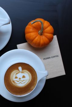 there is a cup of coffee on the table with a pumpkin in the foamy liquid