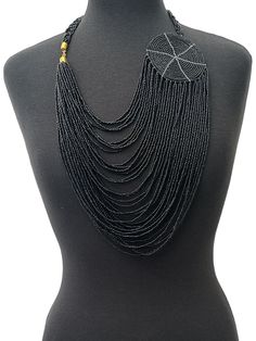 This is an authentic African necklace with a multilayered design and a large disc pendant. The necklace features gold brass and is made of black beads colour. The style of the necklace is beaded and the pendant is beautifully crafted to add to its unique appeal. The necklace is perfect for anyone who loves ethnic and regional-style jewellery. It is ideal for wearing to special occasions and events or to complete an everyday look.  Colour - Black Length - 22inches Material : Beads, Brass Bohemian Black Multi-strand Beads, Black Multi-strand Necklace, Traditional Black And Gold Beads, Traditional Black Beaded Chain, Adjustable Black Necklace With Gold Beads, Black Bohemian Necklaces With Polished Beads, Traditional Black Multi-strand Jewelry, Black Bohemian Necklace With Polished Beads, Handmade Multi-strand Black Necklace