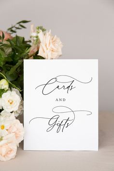 a white card with the words cards and gifts written on it next to some flowers