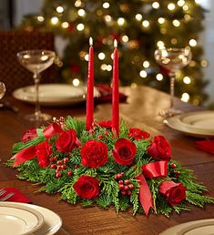 a christmas centerpiece with red roses and greenery