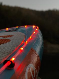 an inflatable raft with red lights on the front and side is seen at dusk