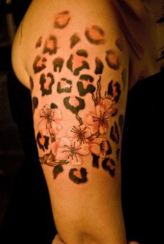 a woman's arm with an animal print and flowers on it