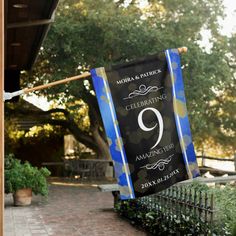 a banner with the number nine on it hanging from a clothes line in front of a house