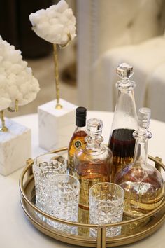 an assortment of liquor bottles and glasses on a tray