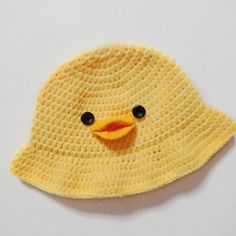 a crocheted yellow duck hat with black eyes