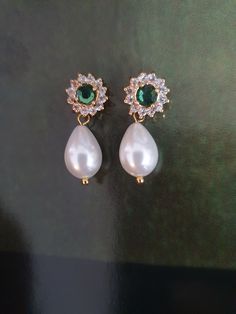 Amazing and OOAK Emerald green earrings, leave stunning impression on everyone! Very classic and has a glamour that can be achieved only with this white pearl and green stone crystals combination: beautiful Swarovski white drop pearls and green Emerald surrounded with tiny crystal Swarovski rhinestones.    I have a matching necklace: https://www.etsy.com/il-en/listing/90528659/bridal-necklace-genuine-emerald-stone?click_key=e18de233524584b28d69e078e8931ba7e38d1eef%3A90528659&click_sum=32f349a7&ref=shop_home_active_9&sts=1 A gorgeous shiny drop pearls earrings features Elegance and style: A beautiful pair made of golden filigree set with Swarovski rhinestone and vintage style pearls, tiny clear crystals and teardrop pearls that has such an impressive style. The back of the earring is ear pi Green Teardrop Pearl Earrings For Wedding, Green Drop Pearl Earrings For Wedding, Elegant Green Jewelry With Pearl Charm, Classic Green Earrings For Wedding, Green Pearl Drop Wedding Jewelry, Green Pearl Drop Jewelry For Wedding, Green Pearl Earrings For Wedding, Classic Green Pearl Drop Earrings, Green Elegant Pearl Drop Earrings