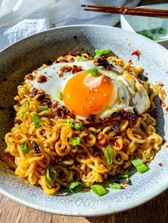 a bowl filled with noodles and an egg on top