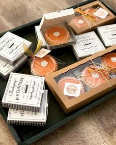 several boxes with different types of cookies in them sitting on a wooden table next to each other