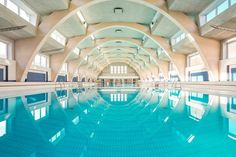 an indoor swimming pool with blue tiles and windows on the ceiling is pictured in this image