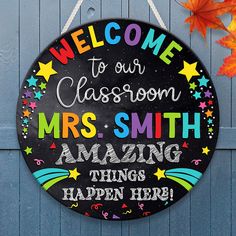 a welcome sign hanging from the side of a blue door that says, welcome to our classroom mrs smith amazing things happen here