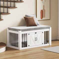 a white storage bench with doors on the bottom and cushioned seat, in front of stairs