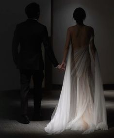 a man and woman holding hands in the dark