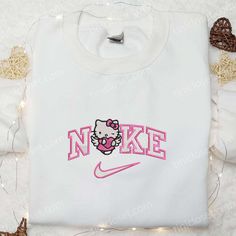 Introducing the Nike x Hello Kitty Angel With Pink Heart Embroidered Shirt, the perfect blend of sporty and cute. Made with high-quality materials, this shirt features a beautiful embroidery of Hello Kitty as an angel with a pink heart. Whether you’re hitting the gym or hanging out with friends, this shirt will make you stand out in style. Its comfortable fit and breathable fabric ensure all-day comfort. Show your love for Hello Kitty and celebrate Valentine’s Day in style with this Embroidery Crewneck, Maroon Hoodie, Embroidered Shirts, Best Valentine's Day Gifts, Bustling City, Hello Kitty Cartoon, Pink Hello Kitty, Embroidered Wedding, Hoodie Material