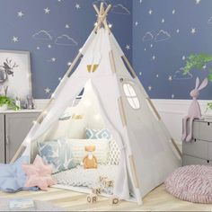 a child's room with a teepee tent and stars on the wall