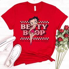 "Betty Boop T-shirt, Original Sass Tee, Officially Licensed Betty Boop Merchandise Shirt, Checkered, Symbol, American Icon, Red Dress * Fashion fit * Clothing style: Athletic * Neckline: Crewneck * Sleeve length: Short sleeve Handmade in our shop with high quality retail printing on a high quality Bella + Canvas fashion t-shirt. Solid Colors - 4.2 oz.(US) 7 oz.(CA), 100% Airlume combed and ringspun cotton Heather Colors - 4.2 oz.(US) 7 oz.(CA), 52/48 Airlume combed and ringspun cotton/polyester Customizing Clothes, Red Dress Design, Betty Boop Shirt, Betty Boop T Shirt, Betty Dress, 1930s Dress, Style Athletic, American Icons, Red Dress Style