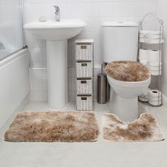 a bathroom with white fixtures and brown rugs on the floor in front of the toilet