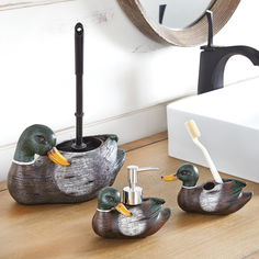 three ducks sitting on top of a wooden table next to a mirror and toothbrush holder