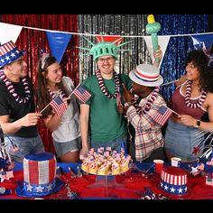 a group of people standing in front of a cake