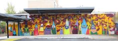 a bus stop covered in lots of colorful surfboards painted on the side of it