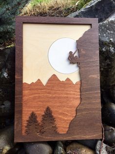 a wooden frame with a silhouette of a man on top of a mountain