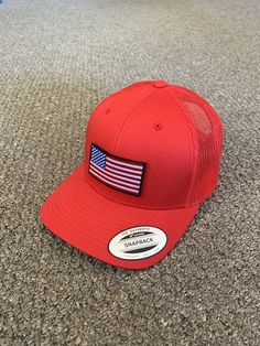 "This is a NEW United States of America Flag Embroidered Patch applied by hand to a high quality Yupoong or Richardson SnapBack trucker hat Yupoong Classic SnapBacks are 65% Polyester/35% Cotton, Structured, mid-profile, 3 1/2\" crown, six-panel Permacurv Visor adjustable plastic snapback closure 6 7/8\" to 7 1/2\" Richardson Hats are 60% cotton/40% polyester Structured, mid-profile, six-panel Pre-curved Visor adjustable plastic snapback closure 6 3/4\" -7 5/8\" Every Hat Design we offer is Crea Patriotic Hats For Outdoor, One Size Fits Most, Patriotic Outdoor Cap, Outdoor Cap Made In Usa, Patriotic Red Snapback Hat With Curved Brim, Red Patriotic Trucker Hat With Curved Brim, Red Patriotic Snapback Hat With Curved Brim, Patriotic Red Trucker Hat With Curved Brim, Red Patriotic Hat, One Size Fits Most, Adjustable American Hat With Curved Brim