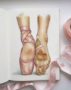 an open book with a drawing of a ballerina's feet and pink ribbon