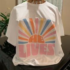 He Lives Easter Graphic Tee Gildan Size Large Brand New Never Worn Easter Holiday Christian Tee Shirt New Condition All Items Shipped 1-3 Days Smoke Free Pet Free Home Sublimation Designs For Shirts Women, Cute Christian Tshirt, Christian T Shirt Design Ideas, Cute Trendy Shirts, Cute Christian Graphic Tees, Graphic Christian Tees, Aesthetic Christian Shirts, Cute Christian T Shirts, Cute Christian Clothes