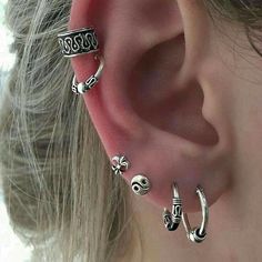 an ear with three different types of piercings on it's sides and one is in the middle