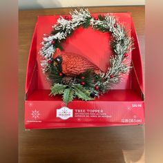 a christmas wreath in a red box on a table