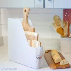 a cutting board with utensils in it next to a knife holder on a kitchen counter