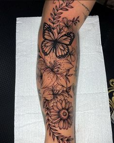 a woman's leg with flowers and a butterfly on it