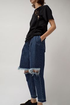 High waist jean with split knee and pieced front panels that mimic cut-off shorts. Four pocket construction, zip fly closure, and belt loops. Edgy Denim Flare Jeans With Frayed Hem, Dark Wash Rigid Denim Cutoff Jeans, Dark Wash Cutoff Cropped Jeans With Five Pockets, Dark Wash Cutoff Cropped Denim Jeans, Dark Wash Cutoff Cropped Jeans, Dark Wash Denim Cutoff Cropped Jeans, Dark Wash Denim Cropped Cutoff Jeans, Cutoff Cropped Jeans In Dark Wash Denim, Cutoff Flare Jeans In Denim Blue