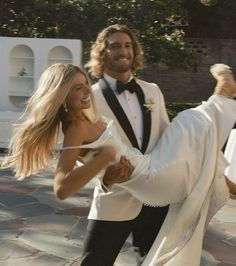 a man in a tuxedo is dancing with a woman