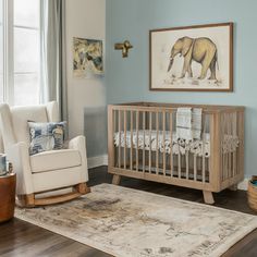 a baby's room with a rocking chair, crib and framed elephant artwork