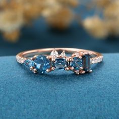 three stone ring with diamonds and blue topazte in rose gold plated setting