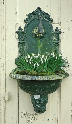 a green planter with white flowers in it