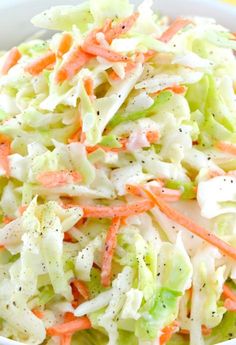 a white bowl filled with coleslaw and carrots on top of a table