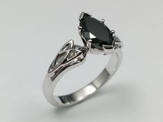 a white gold ring with a black diamond