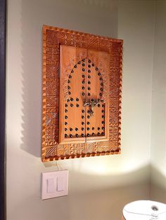 a wooden door hanging on the wall next to a white table and light switch box