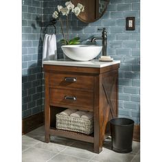 a bathroom vanity with a bowl sink and blue tiles on the wall in the background