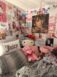 a bedroom with many pictures on the wall and stuffed animals sitting on top of the bed