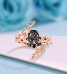 a black and white diamond ring sitting on top of a table