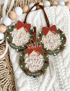 three christmas wreaths with words on them are hanging from a wicker basket next to eggs