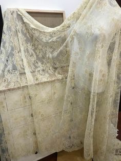 an old white lace curtain is on display