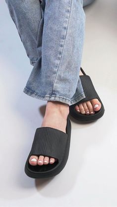 a person wearing black sandals and jeans