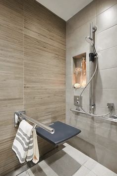 a bathroom with a towel rack, shower head and glass door on the wall next to it