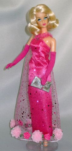 a barbie doll dressed in pink and holding a purse