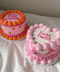 two birthday cakes sitting on top of a bed