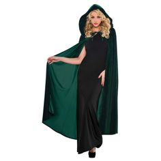 a woman wearing a green cape and black dress with her hands on her hips, posing for