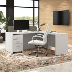 an office desk with two monitors and a chair in front of it on top of a rug